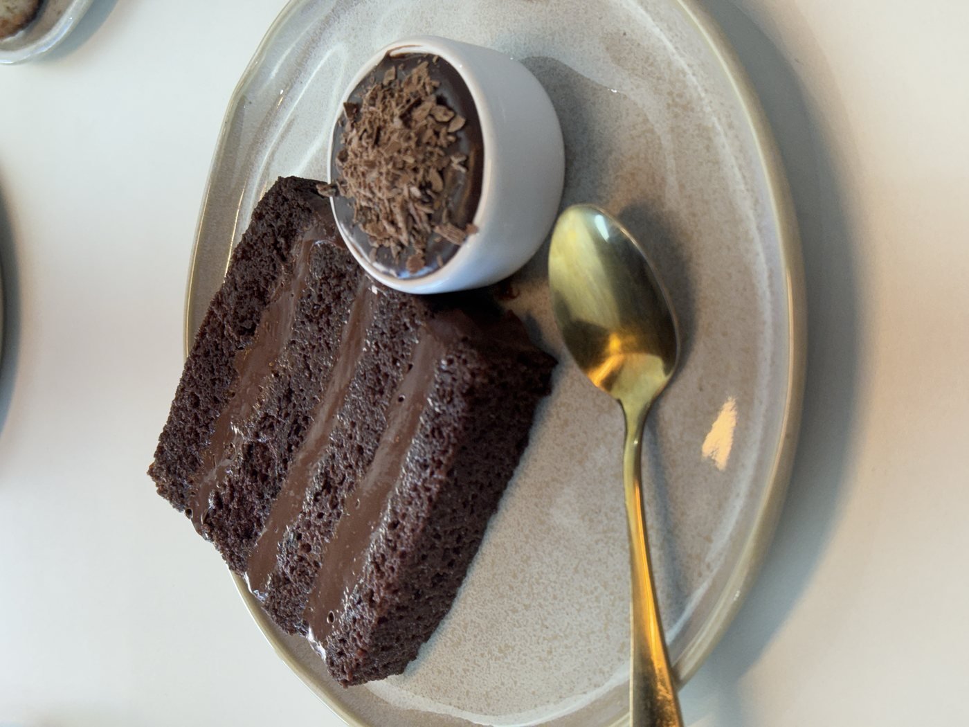 Fatia de bolo de chocolate com potinho de mousse e raspas de chocolate