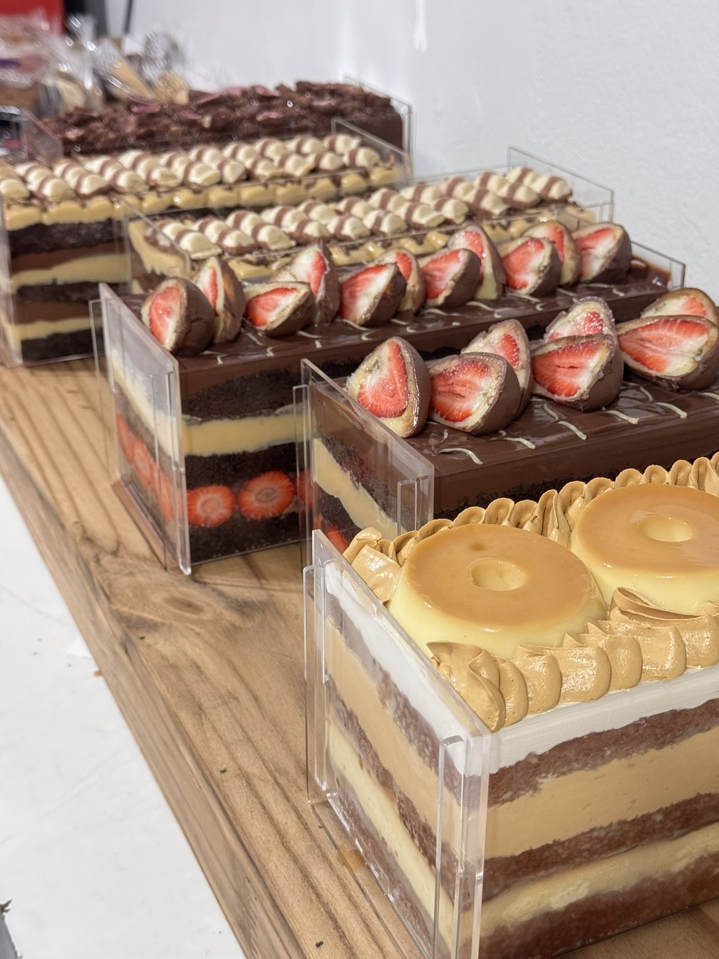 Naked cakes em camadas com morango, brigadeiro e doce de leite, dispostos em bandejas